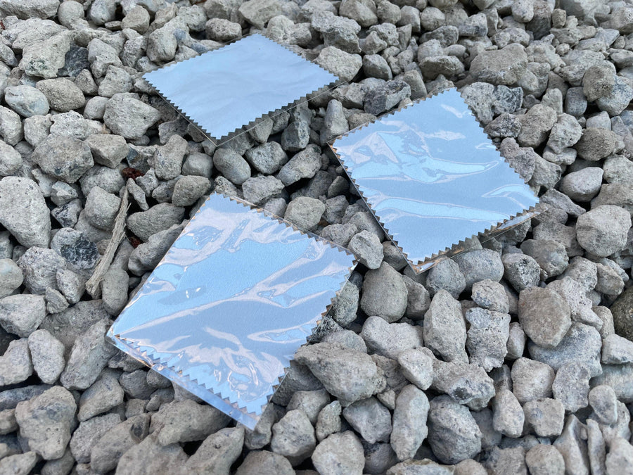 picture of 3 jewelry polishing cloths laying on river stones