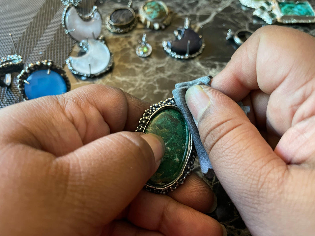 folded jewelry polishing cloth being used to remove the patina from a sterling silver ring