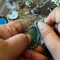 folded jewelry polishing cloth being used to remove the patina from a sterling silver ring