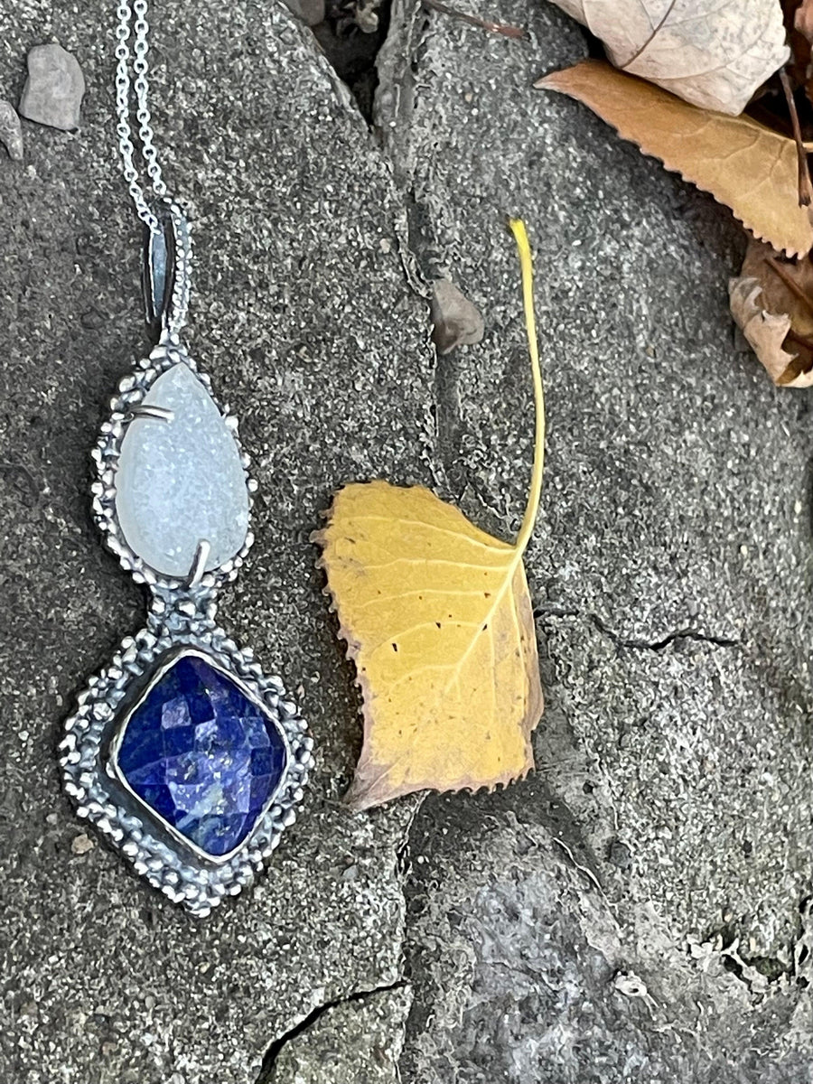 Majestic Necklace lying on stone and leaf background side view. Bohemian necklace Bold necklace Beautiful necklace Sterling silver necklace Goddess necklace Sexy necklace Textured necklace Statement necklace Unique necklace Cosmic necklace Lapis Lazuli Necklace Quartz Druzy Necklace Blue Stone Necklace White Stone Necklace Blue and White Stone Necklace