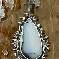 Snow White Necklace lying on wood and snow. Bohemian necklace Bold necklace Beautiful necklace Sterling silver necklace Goddess necklace Sexy necklace Textured necklace Statement necklace Unique necklace  Cosmic necklace Dendritic Opal Necklace White Stone Necklace